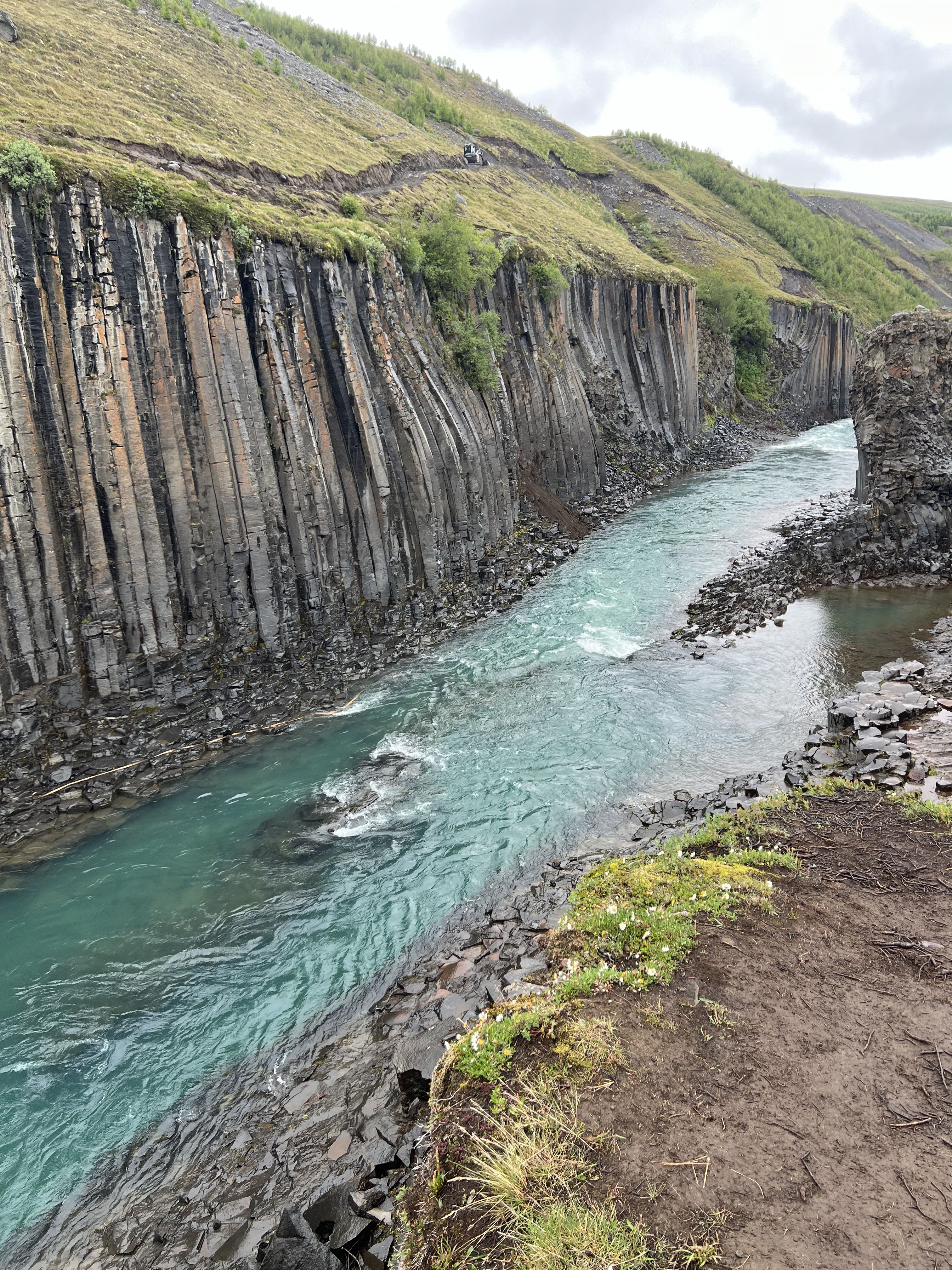 Basalt columns and blue-green river in Stuðlagil Canyon