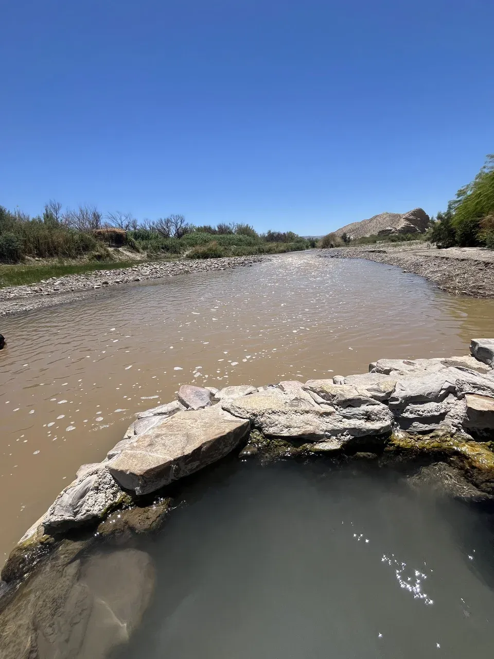 Small stone-edged hot spring directly beside the Rio Grande
